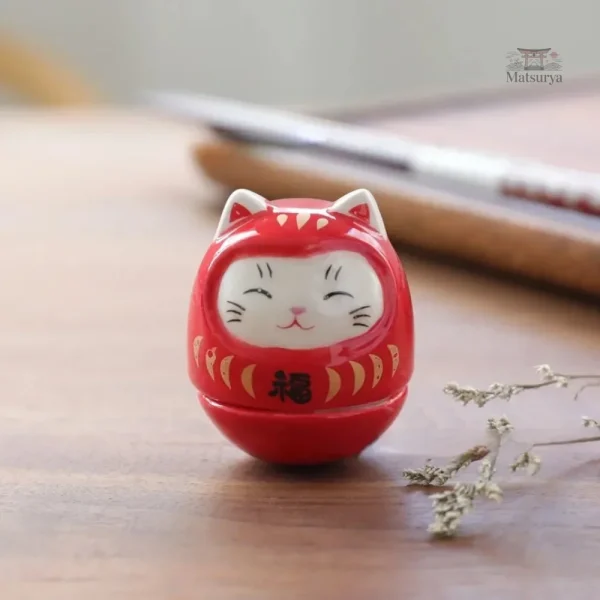Daruma chat en céramique colorée, symbole de chance